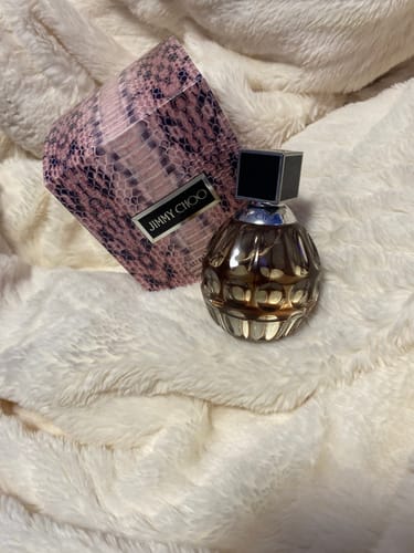 Reviewer's Jimmy Choo For Women perfume, showing the textured glass bottle and pink snakeskin box.