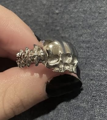 Customer holding the silver Triple Threat Ring, showing the detailed spinal cord design on the side.