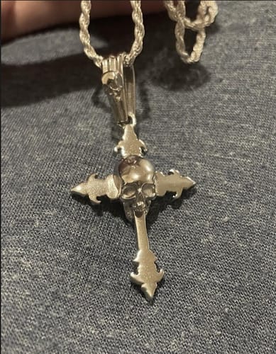 Customer's silver DOWN YOUR THROAT PENDANT on a rope chain, resting on a grey fabric surface.