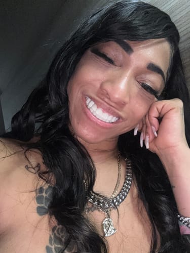 Reviewer smiling happily while showing off their bright white Pop On Veneers.