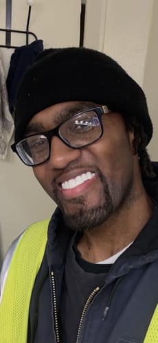 Reviewer smiling confidently in a close-up photo, showing his bright white Pop on Veneers.