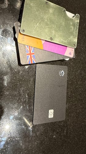 Customer's black SPOTMINDERS Tracking Card PRO on a countertop next to a card holder.