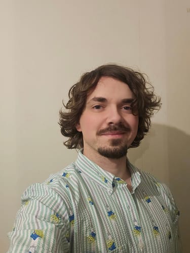 Reviewer in a close-up photo wearing the striped Toy Story "The Claaaaaw" Seersucker Shirt.