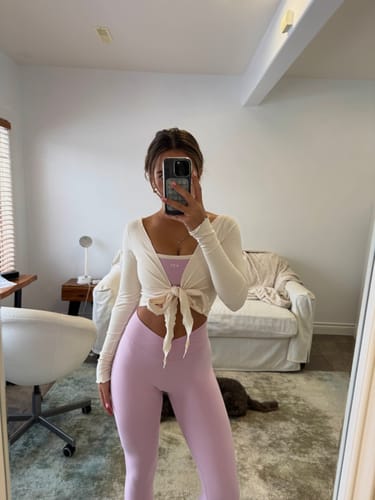 Reviewer takes a mirror selfie wearing the parfait-colored Micro Bra, visible under a cream wrap top.