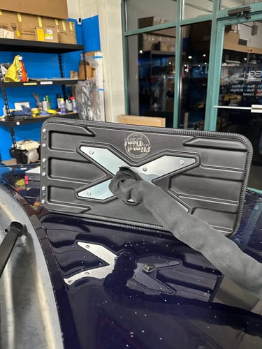 Customer's black X-Factor Mini light, showing the 'X' design on its back while mounted to a dark car hood.