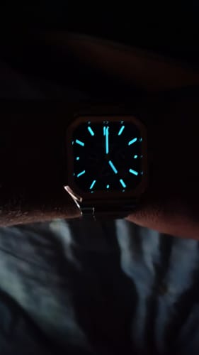 Reviewer's Oceaneva watch on their wrist, showing the luminous hands and markers glowing in the dark.