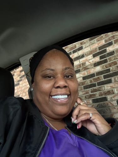 Reviewer smiling in a car, showing her new set of custom made Pop On Veneers.