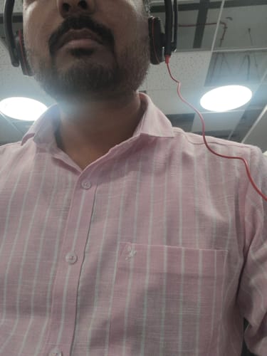 Reviewer in a close-up shot wearing the Rose Pink & White Stripes shirt, showing the collar and pocket.