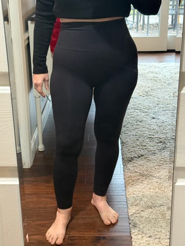 Reviewer showing the front fit of the high-waisted, black Ellis Seamless Tights while standing indoors.