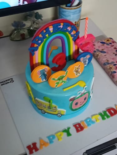 Customer's blue Cocomelon Animals Cake featuring a colorful rainbow topper and character decorations for a third birthday.