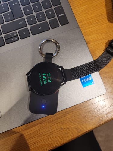 Customer's black MagBank Watch with a keyring charging a smartwatch on a laptop.