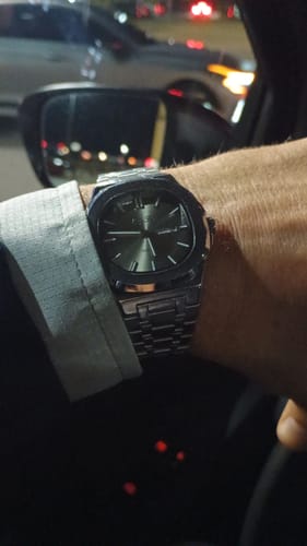 Reviewer wearing their Lucky Fours® Brone watch with a dark face and metal band while in a car at night.