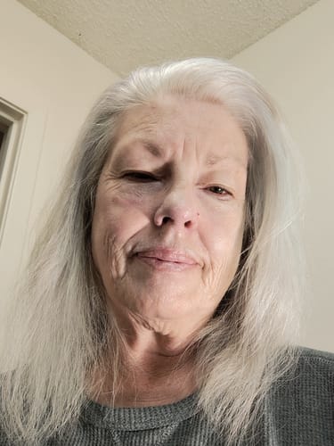 Close-up of a reviewer's happy face after applying the Grass Fed Tallow & Honey Balm.