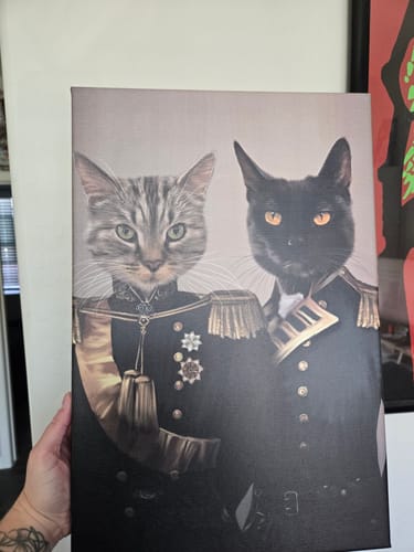 Customer holding The Brothers In Arms Custom Pet Canvas featuring a grey cat and a black cat in military uniforms.