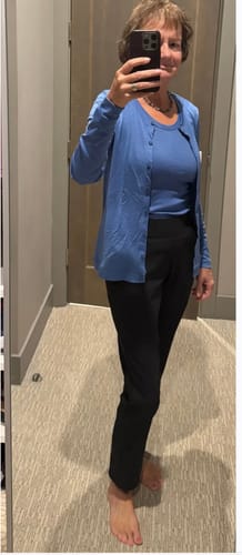 Reviewer in a fitting room wearing the black Nicole Ankle Pants.