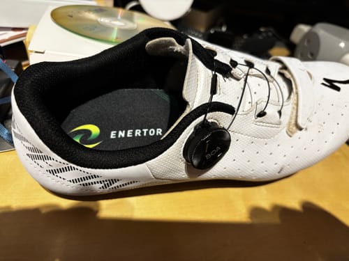 Customer showing the insole from their Runner's Bundle inside a white cycling shoe.