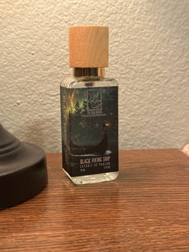 Customer's bottle of Black Viking Ship perfume with a wooden cap, shown on a tabletop.