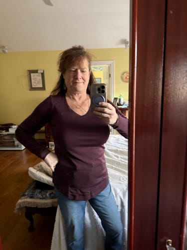 Customer taking a mirror selfie while wearing the V-neck Eva Tunic in Chocolate Fig.