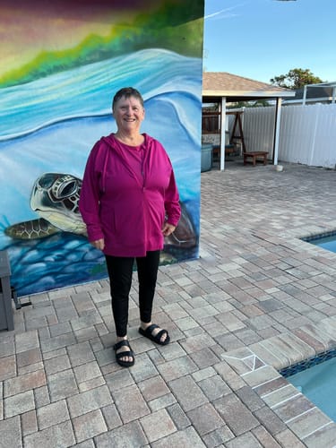 Reviewer standing outdoors wearing the full-length black Merino Flex McKenna leggings.