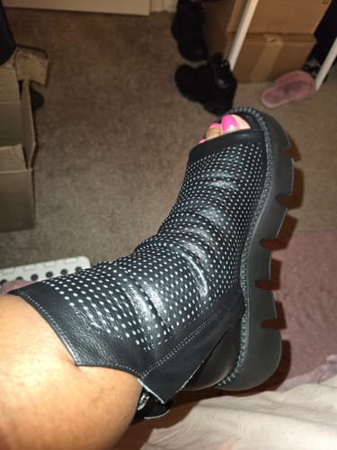 Customer wearing the black Urban Hollow Platform Shoe, showing the fit around their ankle and leg indoors.