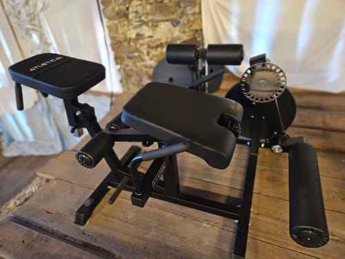 Schwarzes Atletica-Beintrainingsgerät eines Kunden, aufgestellt in einem Heim-Fitnessstudio.