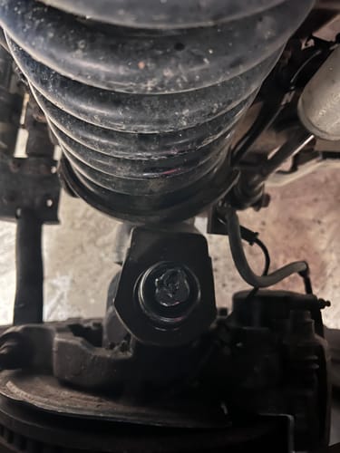 Customer's close-up view of a newly installed Cummins ball joint under the vehicle's suspension coil.
