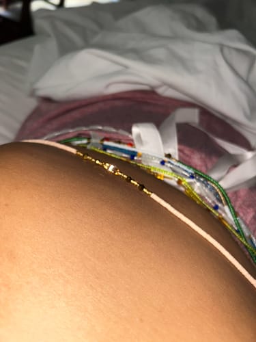 Close-up: A customer wearing several colorful strands of Bella Flat Tie On Waist Beads around their waist.