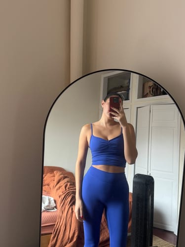 Reviewer in a mirror selfie wearing the blue Essentials Legging and a matching workout top.