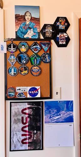 Customer's framed B1058: Flight Proven print displayed on a wall with other NASA memorabilia.