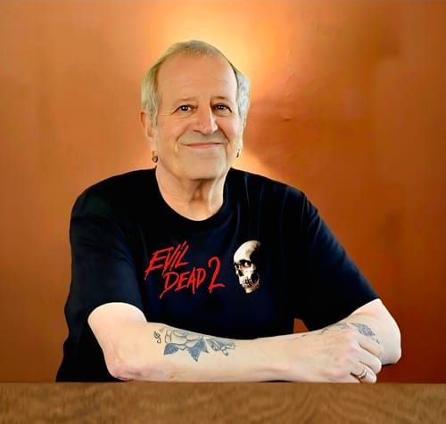 Reviewer smiling while wearing a black unisex t-shirt with an "Evil Dead 2" graphic printed on the front.