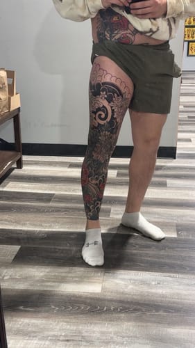 Customer showing a large, detailed tattoo covering their full leg after using Painless Tattoo numbing cream.