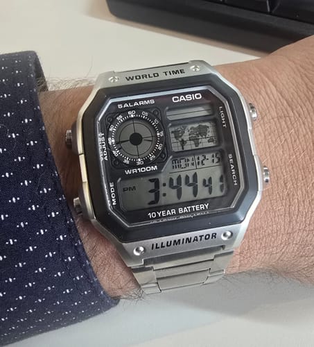 Un cliente muestra en su muñeca el reloj Casio World Time Royale plateado.