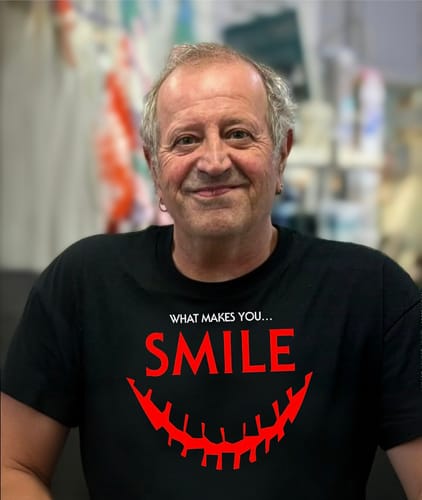Reviewer smiling while wearing the black unisex t-shirt with a red 'SMILE' horror-themed graphic.