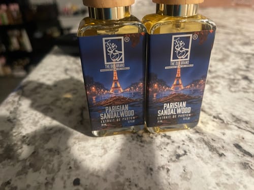 Customer's two bottles of Parisian Sandalwood perfume standing side-by-side on a marble countertop.