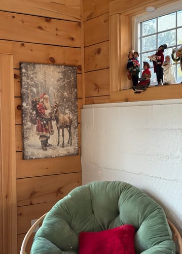 Customer's Vintage Woodland Santa Christmas Wall Art hung on a rustic wood wall next to a window.
