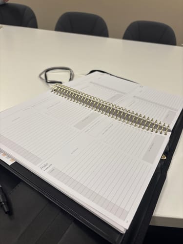 Customer's black 2026 Business Planner open on a desk, showing the weekly layout pages.