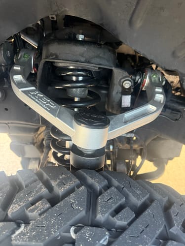 Customer's close-up of the 2" front leveling lift kit installed on a truck's suspension with a silver KSP control arm.