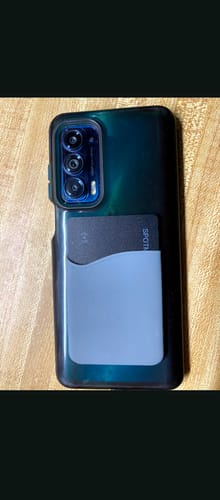 Customer's SPOTMINDERS Tracking Card attached to the back of a phone inside a light-blue wallet sleeve.