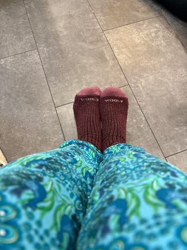 Reviewer wearing the warm Cozy Mini Crew Socks in Grape Harvest on a tiled floor.