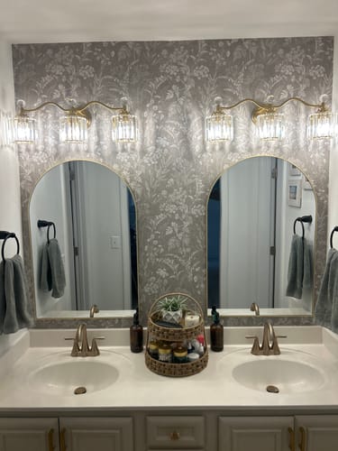 Customer's bathroom with the gray floral Winsome Wallpaper installed above a double sink vanity.
