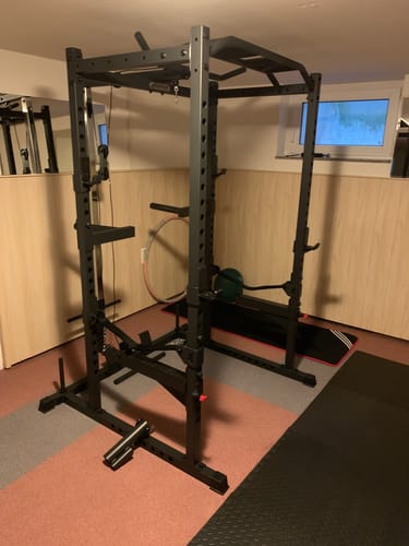 Kundenbewertung des montierten schwarzen R5 Combat Power Racks in einem Heim-Fitnessstudio.
