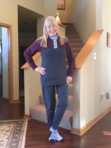 Reviewer standing indoors wearing the deep navy Willa Joggers, showing the full-length relaxed fit and cuffed ankles.