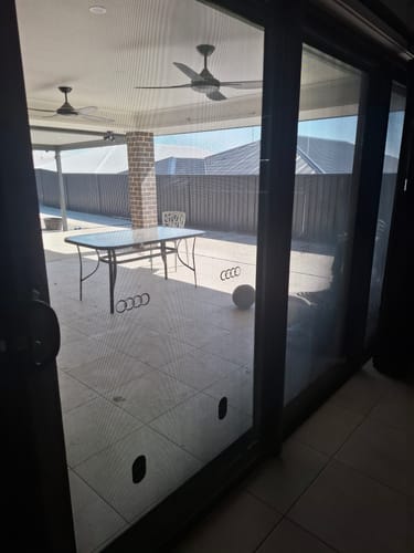 Customer shows a sparkling clean sliding door after using the KoalaCloth, offering a perfect view of the patio outside.
