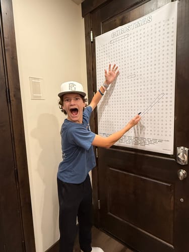 Reviewer excitedly working on the Merry Christmas Giant Crossword Puzzle hung on a door.