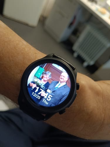 Vásárló fekete Meditime Egészségügyi Okosórája a csuklóján, személyre szabott fotós számlappal.