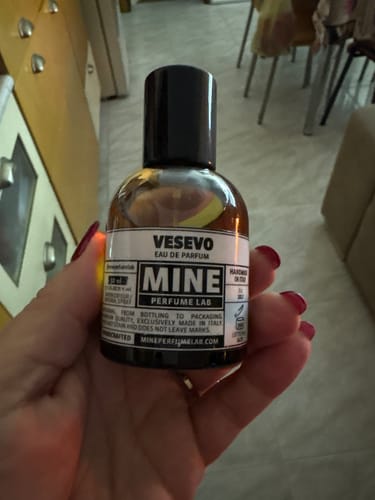 Cliente che tiene in mano la boccetta di vetro ambrato dell'eau de parfum VESEVO.