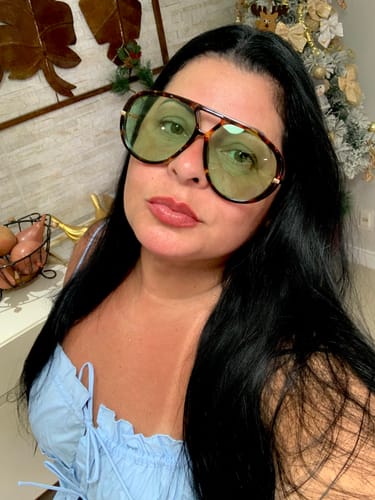 Cliente usando os Óculos Tropea, mostrando a armação tartaruga estilo aviador e as lentes verdes.
