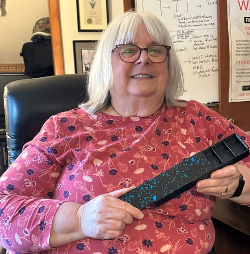 Reviewer smiling while holding the black med box with a blue splatter design from the 2-Pack Bundle.
