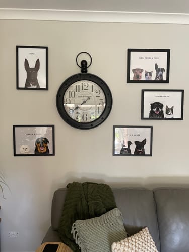Reviewer's wall displaying five framed Custom Pet Portraits of their rescued dogs and cats around a large clock.