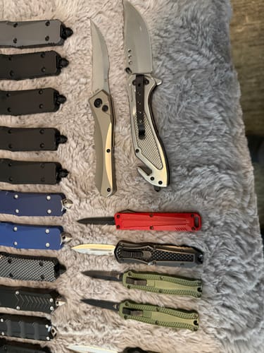 Close-up of a customer's collection of OTF knives in various colors and sizes, including the Small OTF knife.
